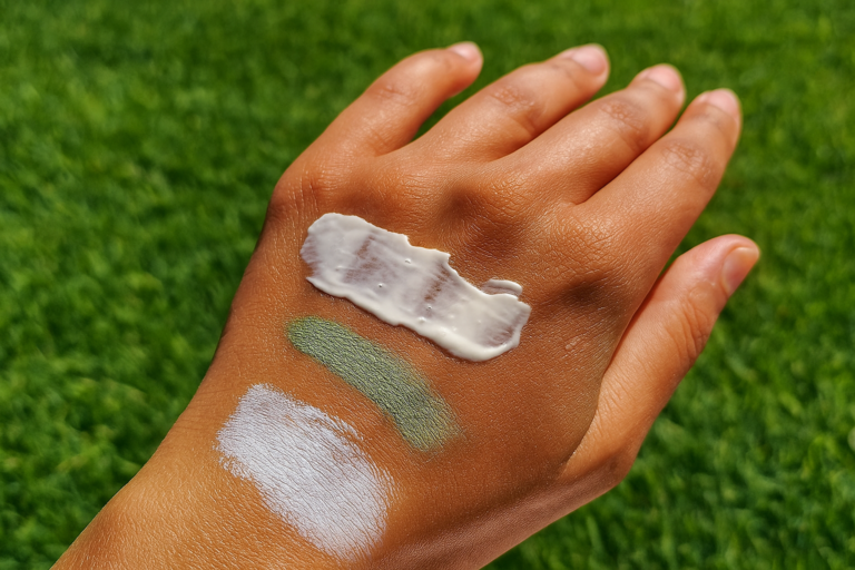 main humaine avec trois types de crèmes solaires différentes